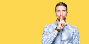 Mavi gözleri olan yakışıklı iş adamı dudaklarında parmak ile sessiz olmak istiyor. Sessizlik ve gizli konsept.