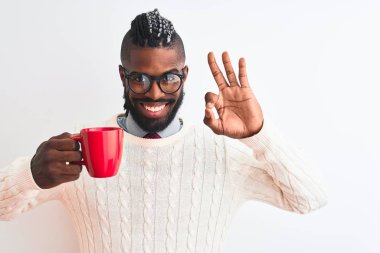 Örgü örüp kahve içen Afrikalı Amerikalı bir adam izole edilmiş beyaz arka planda tamam işareti yapıyor, mükemmel bir sembol.