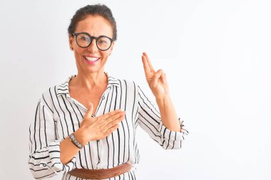 Orta yaşlı iş kadını, çizgili elbise ve gözlük takıyor, beyaz arka planda gülümsüyor, el ve göğsü havada küfür ediyor, sadakat yemini ediyor.