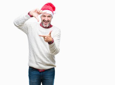 Elle yapma çerçeve ve parmakları ile mutlu yüz gülümseyen izole arka plan üzerinde Noel şapka orta yaş ağarmış komuta sizde. Yaratıcılık ve Fotoğrafçılık kavramı.