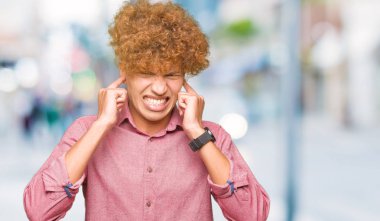 Yüksek sesle müzik gürültü rahatsız ifade parmaklarıyla kulaklarıyla kapsayan afro saçlı Genç yakışıklı iş adamı. Sağır kavramı.