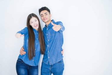 Beyaz tenli güzel Asyalı çift el hareketleriyle olumlu jest yapmayı onaylıyor, gülümsüyor ve başarı için mutlu. Kazanan jest.