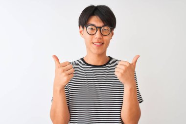 Gözlüklü ve donanma tişörtlü Çinli bir adam izole edilmiş beyaz arka plan işareti üzerinde duruyor. Elleriyle olumlu jest yapıyor, gülümsüyor ve mutlu. Neşeli ifade ve kazanan jest.