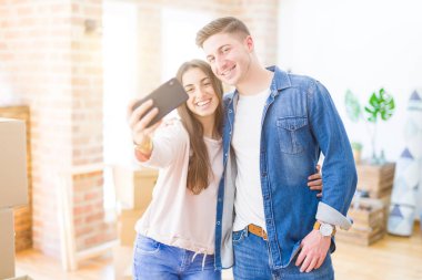 Güzel genç çift akıllı telefon ile bir selfie fotoğrafı alarak mutlu gülümseyen, çok yeni bir eve hareket heyecanlı