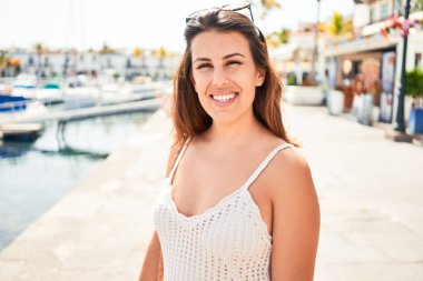 Puerto de Mogan 'ın renkli köyünde genç ve güzel bir kadın. Yaz tatilinde sokakta mutlu bir şekilde gülümsüyor.