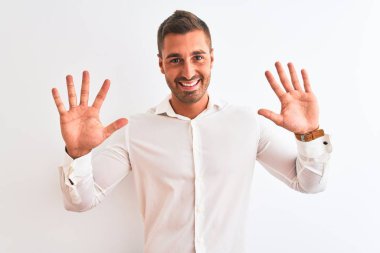Soyutlanmış arka planda zarif gömlekler giyen genç yakışıklı iş adamı on numarayı gösterip işaret ederken kendinden emin ve mutlu bir şekilde gülümsüyor..