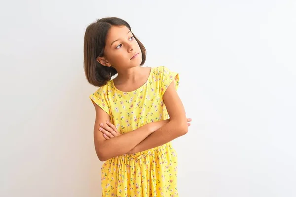 年轻美丽的小女孩穿着黄色的花衣 站在孤零零的白色背景上 手挽手朝旁边看去 她自信而自信 — 图库照片