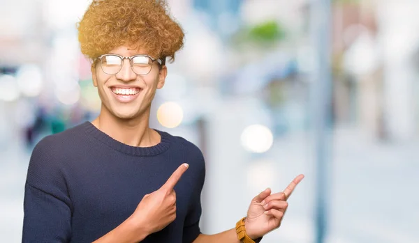 Pemuda Tampan Dengan Kacamata Afro Tersenyum Dan Melihat Kamera Menunjuk — Stok Foto