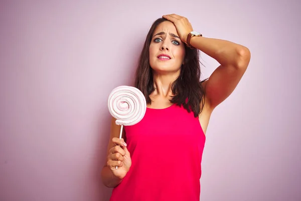 Joven Hermosa Mujer Comiendo Dulces Sobre Rosa Fondo Aislado Estresado —  Fotos de Stock