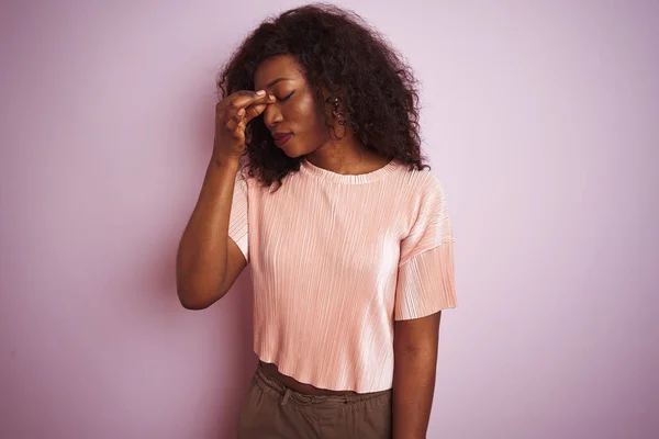 Tシャツを着た若いアフリカ系アメリカ人女性がピンクの背景に立って疲れ鼻と目をこすり疲れや頭痛を感じている ストレスとフラストレーションの概念 — ストック写真