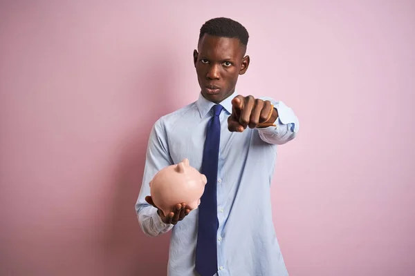 Empresário Afro Americano Segurando Mealheiro Sobre Fundo Rosa Isolado Apontando — Fotografia de Stock