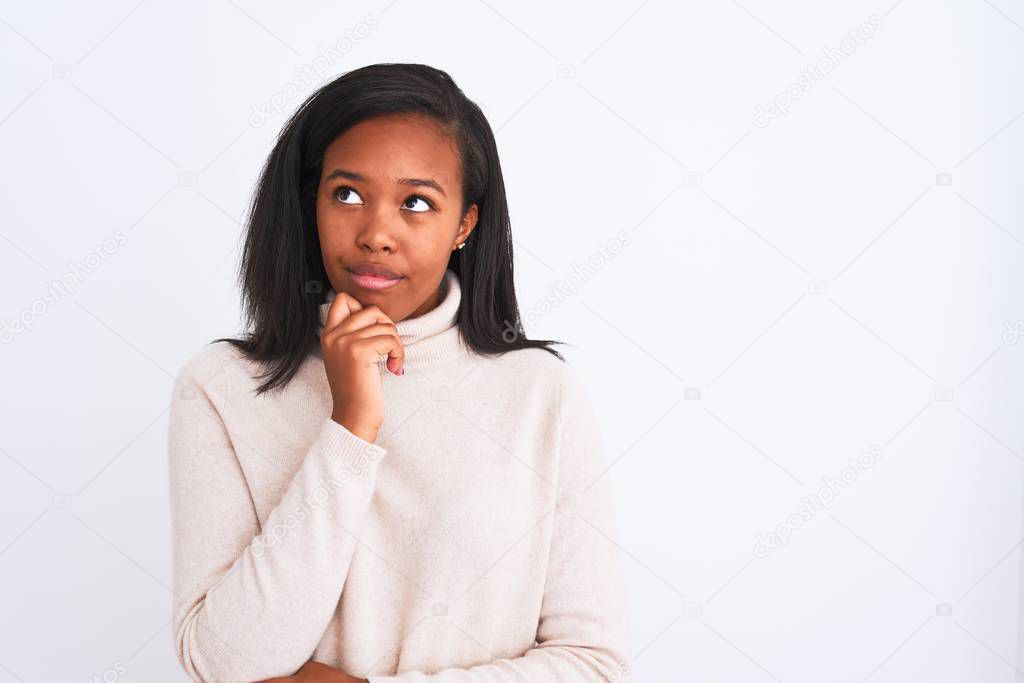 Beautiful young african american woman wearing turtleneck sweater over isolated background with hand on chin thinking about question, pensive expression. Smiling with thoughtful face. Doubt concept.
