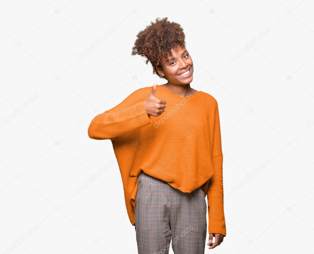 Beautiful young african american woman over isolated background doing happy thumbs up gesture with hand. Approving expression looking at the camera with showing success.