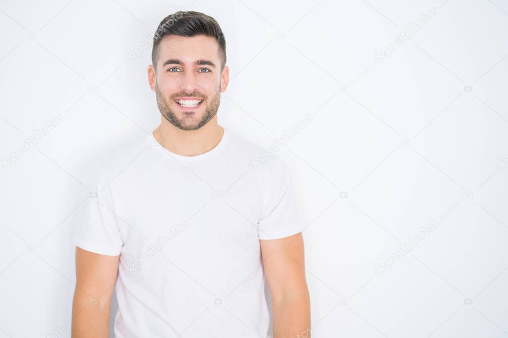 Young handsome man wearing casual white t-shirt over white isolated background with a happy and cool smile on face. Lucky person.
