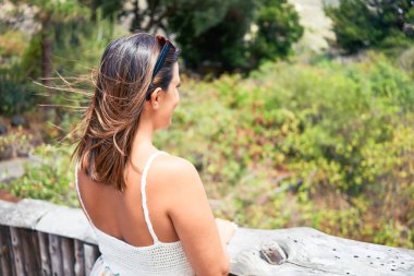 Güneşli bir yaz gününde yeşil parkta mutlu ve neşeli gülümseyen güzel bir kadın.