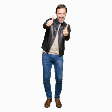 Siyah deri ceket onaylama giyen orta yaş yakışıklı adam el ile pozitif jest yapıyor gülümseyen ve başarı için mutlu yaşasın. Kamera, kazanan jest arıyorsunuz.