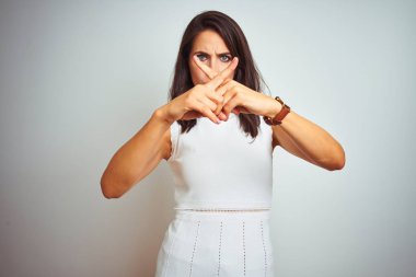 Genç ve güzel bir kadın beyaz arka planda dikiliyor. Reddedilme ifadesi olumsuz işaret veriyor.