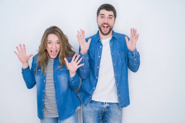 Genç ve güzel bir çift, beyaz soyutlanmış arka planda bir arada durup çılgın ve başarıyı kollarını kaldırıp heyecanla haykırarak kutluyor. Kazanan konsept