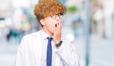 Genç yakışıklı bilim adam gözlük esneme sıkılmış kapsayan ağız el ile yorgun. Restless ve uyku hali.