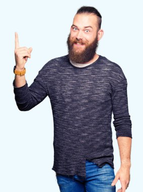 Genç Sarışın başarılı fikirle giyen sıradan kazak işaret parmağı adam. Çıktıktan ve mutlu. Bir numara.