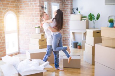 Karton kutular etrafında yeni evde sarılma genç güzel çift