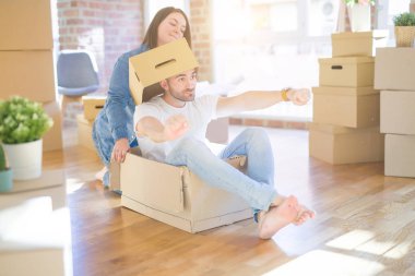 Komik ve çılgın çift bir araba olarak bir cardboad kutusu sürme eğlenceli sahip, mutlu gülümseyen ve yeni evde gülüyorsun