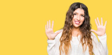 Beyaz kazak giyen genç güzel kadın gösteren ve parmakları ile işaret on numara emin ve mutlu gülümserken.