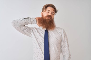 Genç kızıl saçlı İrlandalı işadamı izole edilmiş beyaz arka planda duruyor boynu ağrıyor, elleriyle boynuna dokunuyor, kas ağrısı çekiyor.