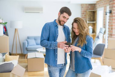 Genç çift cardb etrafında akıllı telefon kullanarak yeni bir eve hareket