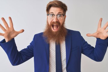 Genç kızıl saçlı İrlandalı işadamı takım elbise ve gözlük giyen izole beyaz arka plan üzerinde deli kutluyor ve kollarını kaldırdı ve açık gözleri heyecan çığlık ile başarı için hayran. Kazanan kavramı