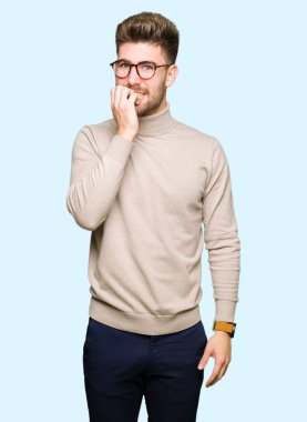 Stresli ve gergin elle çivi ısırma ağzına bakarak gözlüklü genç yakışıklı iş adamı. Anksiyete sorunu.