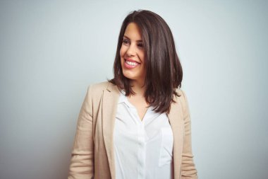 İzole arka plan uzak tarafına gülümseme ile yüzünde, doğal ifade seyir üzerinde genç güzel şık iş kadını. Kendine güvenen gülüyor.