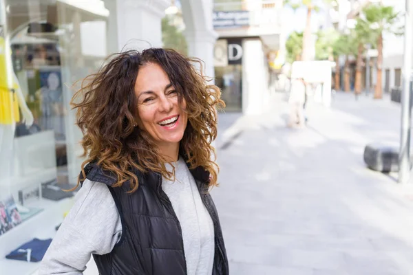 Vacker sportig kvinna med lockigt hår leende glada promenader — Stockfoto