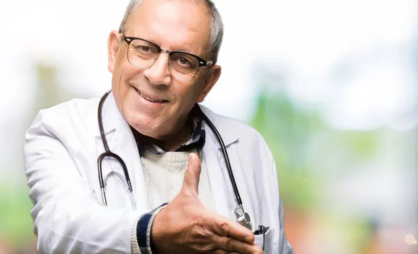 医療コートを着たハンサムな先輩医師男性が笑顔で挨拶と歓迎として握手を交わす ビジネスの成功 — ストック写真