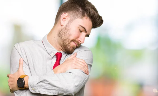 Young handsome business man Hugging oneself happy and positive, smiling confident. Self love and self care