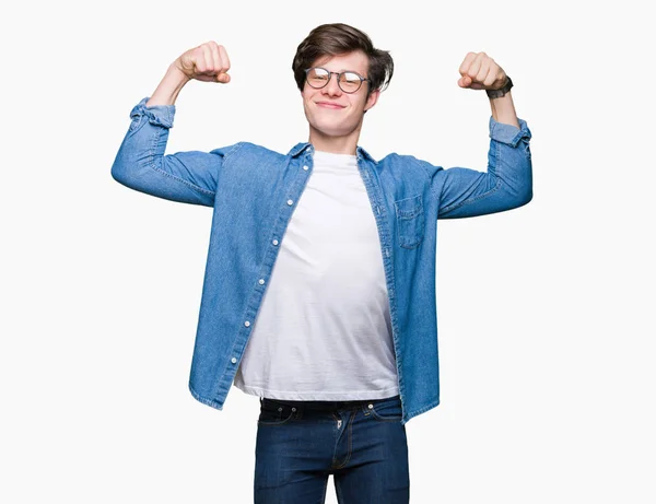 Homem Bonito Jovem Usando Óculos Sobre Fundo Isolado Mostrando Músculos — Fotografia de Stock