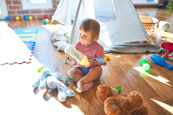 Adorable Niño Pequeño Sosteniendo Biberón Alrededor Muchos Juguetes Jardín Infantes — Foto de Stock