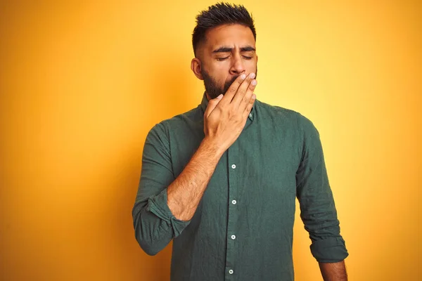 Young indian businessman wearing elegant shirt standing over isolated white background bored yawning tired covering mouth with hand. Restless and sleepiness.