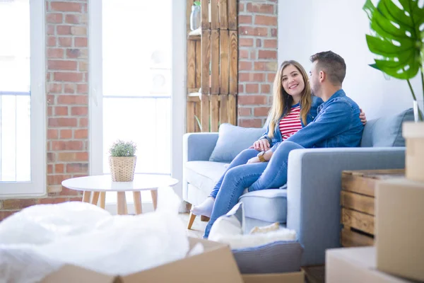 Joven Hermosa Pareja Sentada Abrazándose Sofá Nuevo Apartamento Con Cajas — Foto de Stock