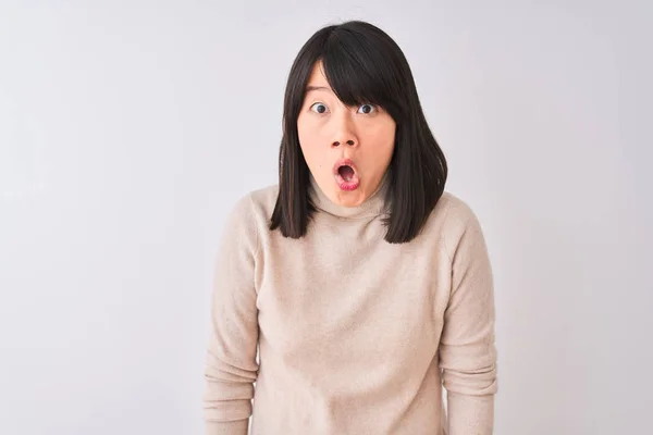 年轻美丽的中国女人 穿着高领毛衣 披着孤立的白色背景 吓得满脸惊讶 恐惧和兴奋 — 图库照片