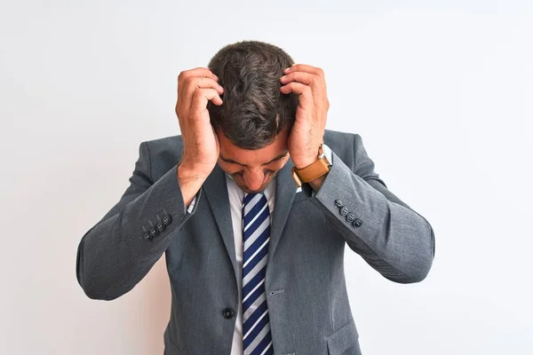 Young handsome business man wearing suit and tie over isolated background suffering from headache desperate and stressed because pain and migraine. Hands on head.