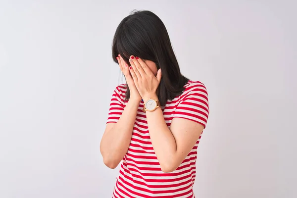 年轻美丽的中国女人 穿着红色条纹T恤 披着孤立的白色背景 脸上挂着忧郁的表情 一边哭一边用手捂住脸 抑郁症的概念 — 图库照片