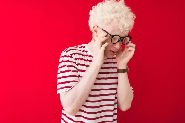 Młody Blondyn Albinos Pasiastej Koszulce Okularach Odizolowanym Czerwonym Tle Ręką — Zdjęcie stockowe