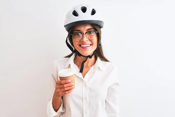 漂亮的女商人戴着自行车头盔 站在孤独的白色背景上喝咖啡 脸上挂着快乐的表情 脸上挂着自信的微笑 露出牙齿 — 图库照片