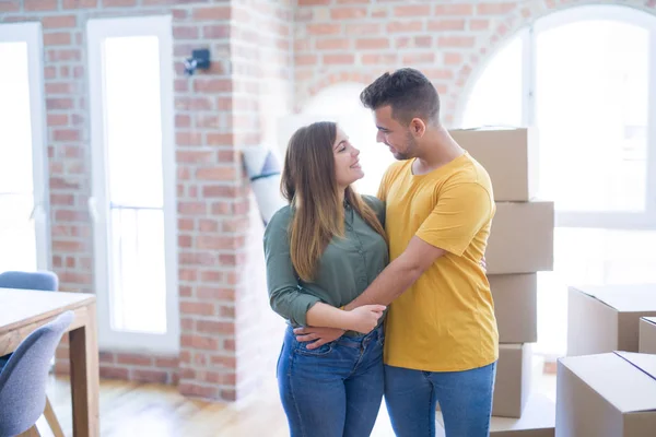 新しい家に移動する段ボール箱の周りに恋する若い美しいカップルは 新しいアパートのために非常に幸せで陽気な笑顔 — ストック写真