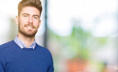 Genç yakışıklı bussines adam gülümseyen neşeli sunulması ve kameraya bakarak avucunun ile işaret.