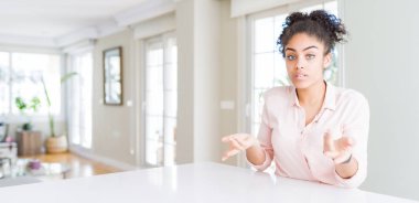 Afro saçlı, kafası karışık ve kolları açık güzel Afro-Amerikan kadını, hiçbir fikrim yok..