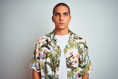 Tatilde beyaz arka plan kuşkucu ve gergin Hawaii gömleği giyen genç yakışıklı bir adam sorun yüzünden surat asıyor. Negatif kişi.
