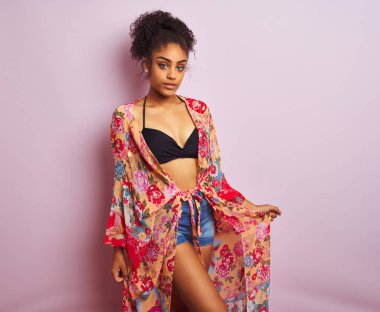 Genç güzel afro-amerikan kadın bikini ve renkli kaftan giyen ayakta tatilde