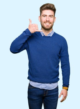 İşin gülümseyen genç yakışıklı bussines adam telefon hareketi ile el ve parmak telefonda konuşuyor gibi. Kavramları iletişim.